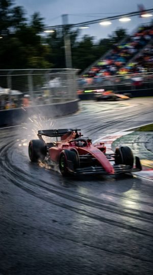 Formula 1 red race car drifting through corner with sparks at night race